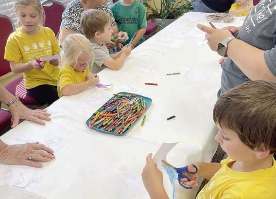 Youngsters work on making mini-lanterns out of plastic cups (top photo) along with coloring and cutting out animals (bottom photo) as part of the program put on by Arts for Rural Texas at the library last Friday. Sticker Photos By Darrell Vyvjala