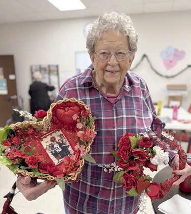 Irene Janda holds at left a heart with her family photo made for her by Martha Beckmann. Then, on Wednesday, Jan. 29, she also won the blackout prize which she holds at right.
