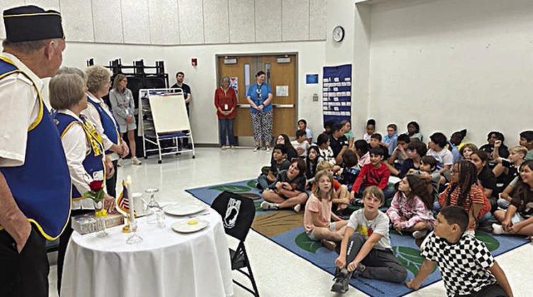 A small table with symbo lic ite ms (shown in both photos) is used during the POW/MIA ceremony, which was presented to SES fifth graders by American Legion Auxiliary members along with Legion members.