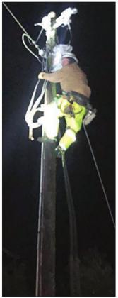 Apprentice Lineman Joey Jasek climbs a pole during the night to pull wire to complete repairs on a downed power line north of Weimar. Photo By FEC Line Foreman Greg Noak