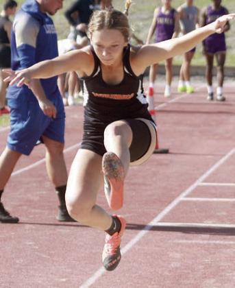 Michaela Kollmann leaps to a fifth-place finish in the triple jump prior to qualifying for regional in the 800-meter run. Sticker Photo By Darrell Vyvjala