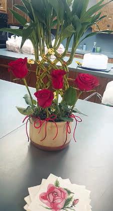Photo at left – Centerpiece. Photo Abo ve – Table centerpiece with bee decorations. Photo at right – Hostesses (from left) Debbie Vellela and Nova Stonecipher.