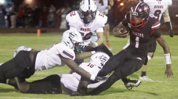 Tavondrick Ellison (No. 10) brings down Jarvse Dickerson for no gain in the second quarter with help from Ceadre Wade and with Max Hernandez (No. 52) closing in. Sticker Photo By Brandt Vyvjala