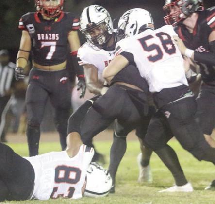 Jayvan Luhrs (No. 83) hangs on as Preston Kahn (No. 58) and DaTerrion Houston help him drop Jarvse Dickerson at the line of scrimmage in the second quarter.