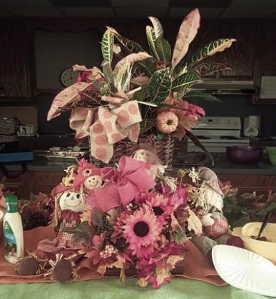 Hostesses for the Garden Club meeting were (from left) Jan Ripper, Wanda Brown and Mary Demel. At right is the centerpiece, which carried out the autumn theme with decorations that included burlap cloths, croton plant, pumpkins and scarecrows.