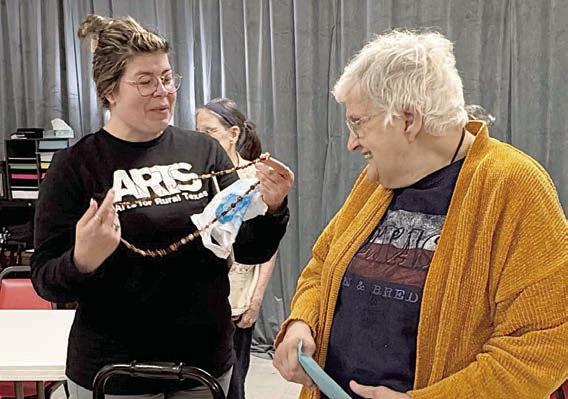 Gifts from the heart were presented by member Cynthia Meyer (right) to Arts For Rural Texas program director Tory Farley (left). Meyer made a beautiful beaded necklace and card to give to Farley for taking her on the adventure of her life to Graceland. Anyone who knows Meyer knows what a role Elvis has played in her life.