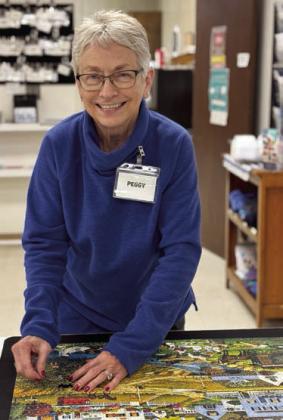 Putt ing in th e final pieces to a puzzle that seemed to never end is Peggy Hiatt. The puzzle sat on the table far too long, stumping members. They are all happy it is complete and they can begin another less complicated puzzle.