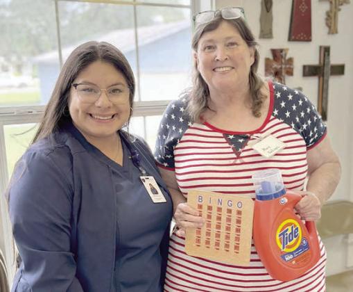 Bingo caller in Flato nia recently was Haylee Austin (left) of Crown Hospice, shown with Mary Kalinec (right), who holds her blackout prize. Kalinec also brought desserts for the day and baked cookies to share with the speakers and bingo callers!