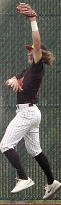 Left fielder Aaron Janecek makes a leaping catch on a deep drive to end the top of the fifth inning in game three. Sticker Photo By Darrell Vyvjala