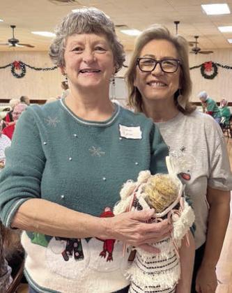 Successfully guessing the number of home-baked cookies in this darling stocking in a game brought by volunteer and board member Cynthia Trojacek (right) was Janiece Collins (left).
