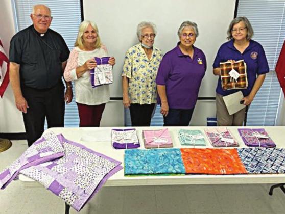 SHOWN WITH PRAYER BLANKETS being constructed in a program recently undertaken by Catholic Daughters Court St. Rose 1597 are (from left) chaplain Rev. Tim Kosler and volunteers Clara Clark, Pat Christ, Rosa Galipp and Karen Miley.