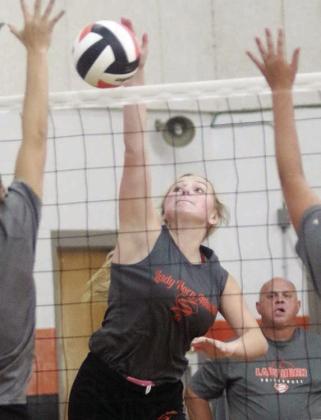 Saybra Pinney gets an attack in between two blockers while head coach Donald Zapalac looks on last Friday. Sticker Photo By Darrell Vyvjala