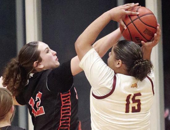 Grace Schramek blocks a shot in the fourth quarter. Sticker Photo By Darrell Vyvjala