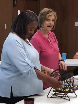 Calling the first bingo game for Senior Connections earlier this month at its new satellite location – First  United Methodist Church in Weimar – was Peggy Pohl (left)  from Prosperity Bank in Weimar. Jennifer Moring (right) of Fayette Savings Bank helped get things started.