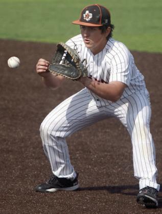 First baseman Ian Reeves gloves a grounder for an out in game one. Sticker Photo By Darrell Vyvjala