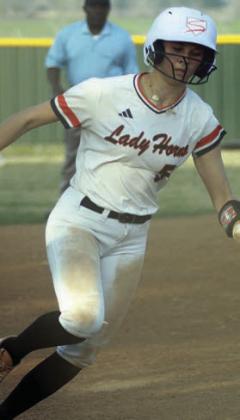 Kinley Tillery rounds third and heads home for the Lady Horns’ only run last Friday. Sticker Photo By Darrell Vyvjala