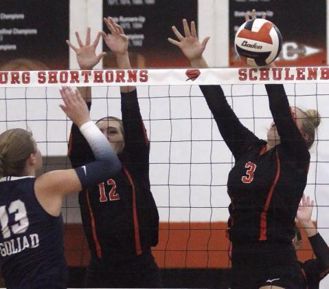 Reagan Dusek (right) knocks back a Goliad attack in the Gold Bracket semifinal. Also shown going up for a block attempt in the first set is Grace Schramek. Sticker Photo By Darrell Vyvjala