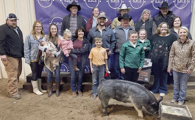 SWINE – Exhibitor: Abraham McBride (front, in green jacket). Weight: 215 pounds. Sales price: $10,500. Sticker Photo By Darrell Vyvjala