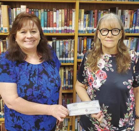 Assistant Librarian Donna Holub (left) and Librarian Cindy Lytle accept the $2,500 check that was received through a grant from the Texas Book Festival.