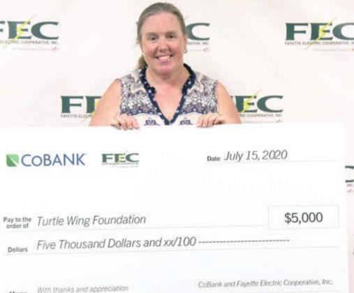 TURTLE WING FOUNDATION received a $5,000 grant from FEC and CoBank. Displaying the check is Turtle Wing managing director Susie Shank.