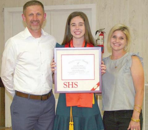 Claire Antosh (center) accepts the valedictorian plaque at the Senior Scholarship and Academic Banquet earlier this month with her parents, Michael Antosh and Erin Bonner. Sticker Photo By Darrell Vyvjala