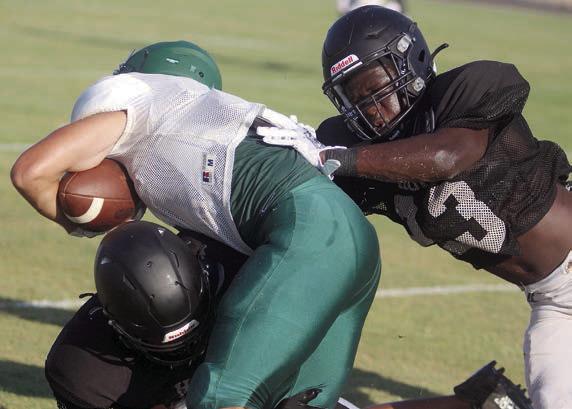 Rodney H Walton (right) and Byron Johnson combine to bring down a Lexington Eagle in last Thursday’s scrimmage. Sticker Photo By Darrell Vyvjala