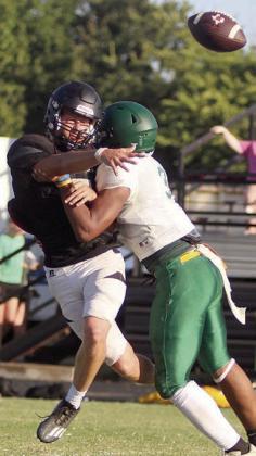 Aaron Janecek gets off a completion under pressure during the Horns’ first scrimmage. Sticker Photo By Darrell Vyvjala