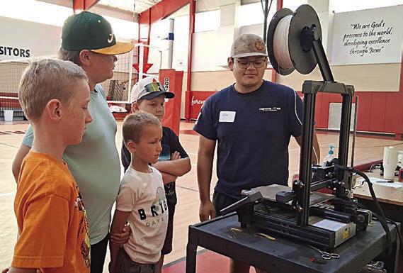 A 3D printer and how to program it is being demonstrated by Noe Nieto (right).