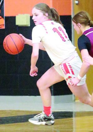 Gracie Burton (left) comes away with a steal in the third quarter Friday and Alana Herzik (above) gets a theft in the second period. Sticker Photos By Darrell Vyvjala