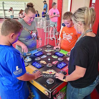 Chaos Challenge – Gamers test their memory recall and reflexes against three other players. In the photo above, St. Rose pre-school teacher Jaime Rainosek (standing at table, second from left) challenges St. Rose health and nutrition teacher Micayla Harden (right).