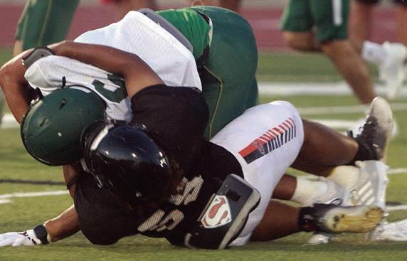 Keigan Johnson brings down a Lexington running back. Sticker Photo By Darrell Vyvjala