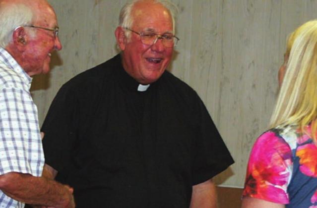 FROM THE JULY 1 ISSUE – The Rev. Timothy Kosler, long-time pastor of St. Rose of Lima Catholic Church, visits during a party which followed his announcement that he was retiring after 50 years in the priesthood.