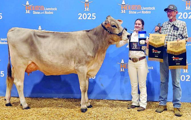 Mikayla Stang (left) won reserve grand champion Brown Swiss female in the open show as well as reserve grand champion Brown Swiss female. She is shown with Mark Miksch (right).