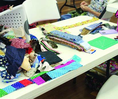 Quilts for area nursing facilities will be constructed at the Colorado Valley Quilt Guild charity workshop on Tuesday, Nov. 28. The process will include (left photo) organizing donated fabrics and (right photo) various stations set up for the streamlined assembly of quilts.