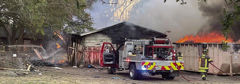 SVFD personnel get the structure fire knocked down but material in a rolloff container continues to burn. Sticker Photo By Darrell Vyvjala
