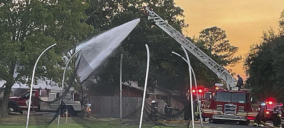 Below: Ladder 4 provides the deluge of water to put out all of the remaining embers. Sticker Photo By Darrell Vyvjala