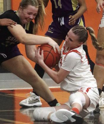Jenna Guentert fights a Lady Comanche for a loose ball in the second half. Sticker Photo By Darrell Vyvjala