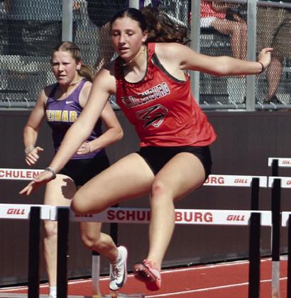 Jordin Davis clears a hurdles on her way to a first-place finish in the 100-meter event. Sticker Photo By Darrell Vyvjala
