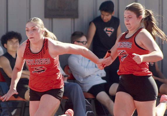 Landry Zapalac (right) hands off to Greenli VanZandt for the second leg of the 800-meter relay. The Lady Horns placed third. Sticker Photo By Darrell Vyvjala