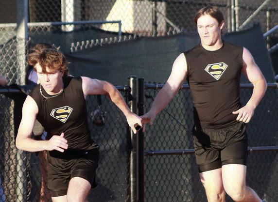 Nick Goode (left) takes the baton from Owen Brenek in the 1600-meter relay. The Horns placed fourth. Sticker Photo By Darrell Vyvjala