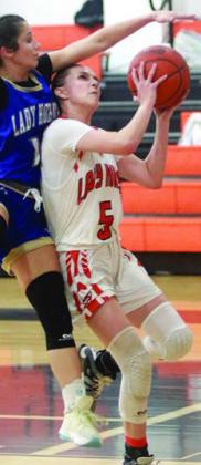 Jenna Guentert gets fouled by a Lady Hornet on her way to the basket. Sticker Photo By Darrell Vyvjala