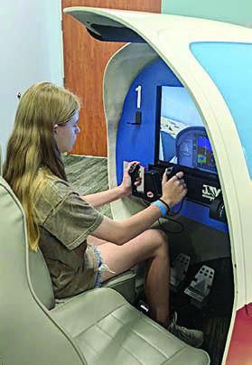 a flight simulator is being experienced by Vyvynne Friemel.