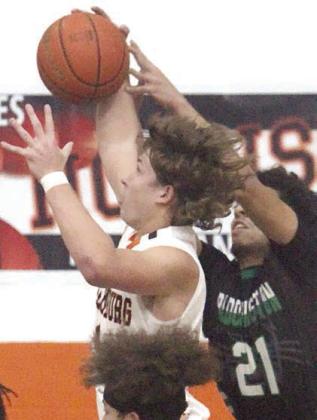 Aaron Janecek pulls down a defensive rebound in the second quarter Friday. Sticker Photo By Darrell Vyvjala