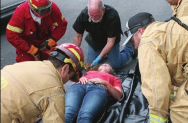 Harly Zapalac gets placed in a body bag for transport to the funeral home. Sticker Photo By Darrell Vyvjala
