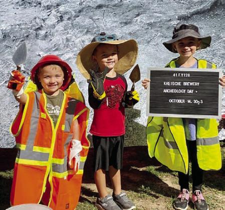 A favorite activity at Archeology Day is “Dress Like an Archeologist,” with three youngsters shown donning the attire at the Archeology Day held in 2023.