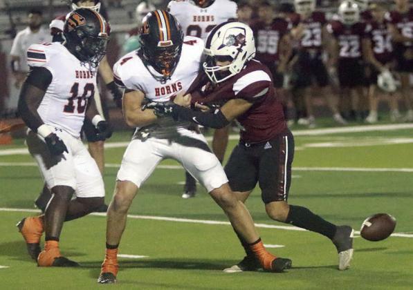 Jayse Janda grabs Luis Vela to thwart a lateral pass in the second quarter. Tavondrick Ellison (No. 10) makes his way to the loose ball, which he returned for a touchdown. Sticker Photo By Layne Vyvjala