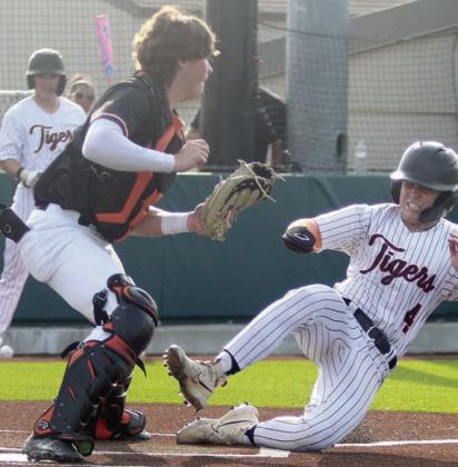 Catcher Jayse Janda takes a throw to force out a Tiger in the first inning of game three. Sticker Photo By Darrell Vyvjala