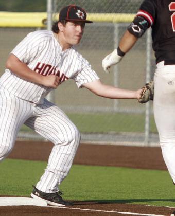 First baseman Ian Reeves adjusts to a wide throw to get an out in game one. Sticker Photo By Darrell Vyvjala