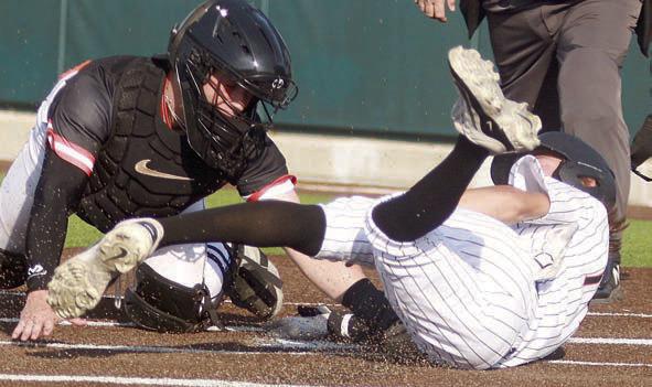 Connor Lichnovsky slides into home for a run in game one. Sticker Photo By Darrell Vyvjala