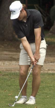 Reid Janda chips onto No. 18 green Monday. Sticker Photo By Darrell Vyvjala